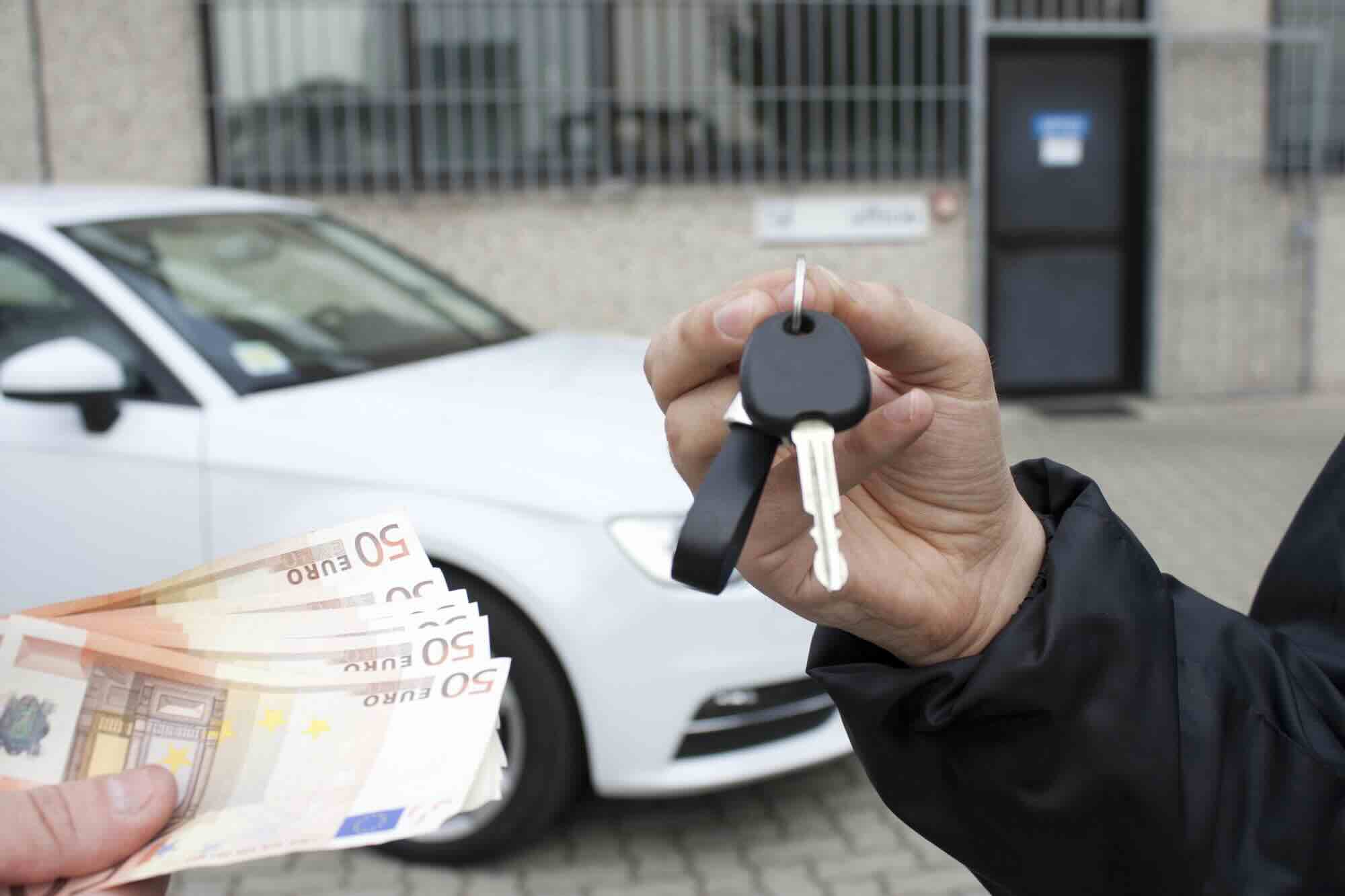 man betaalt contant geld voor een auto