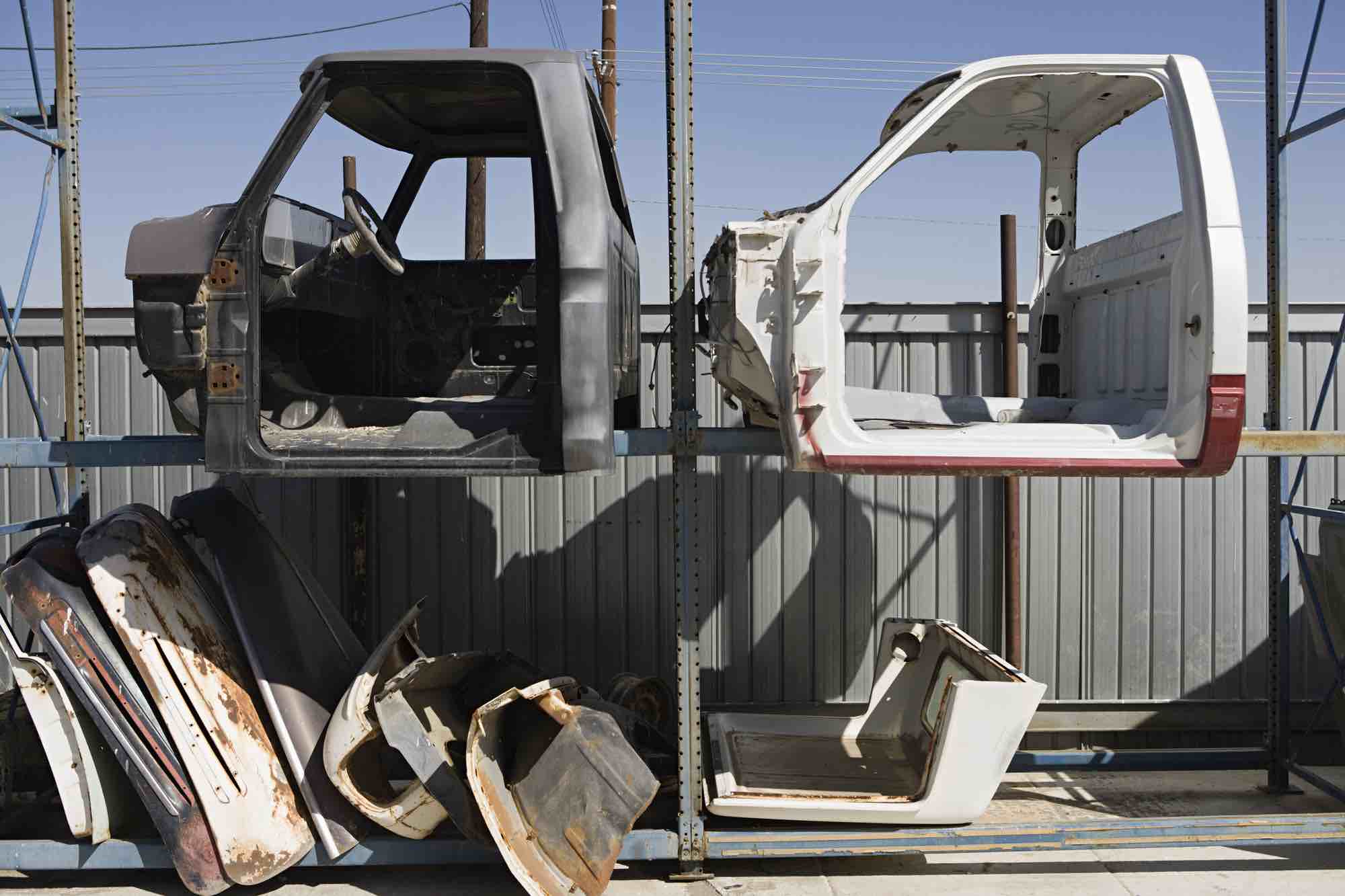 gedemonteerde auto onderdelen in stellage bij autosloperij